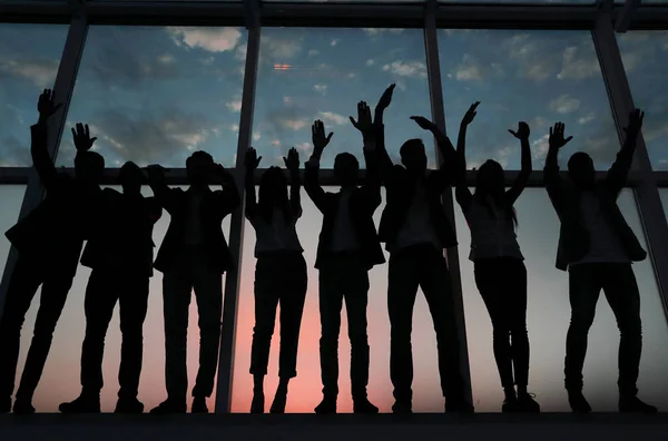 Silueta de un grupo de empresarios levantando la mano — Foto de Stock