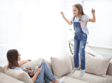 Anne ve küçük kızı oturma odasında kanepede oynuyorlar