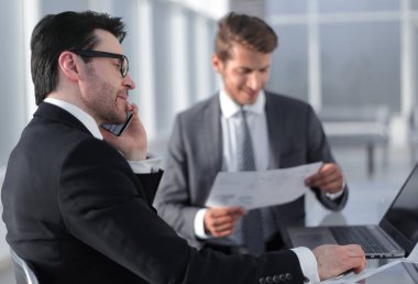 çalışanların yeni veriyi denetlemek için bir dizüstü bilgisayar kullanmak.