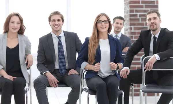 Grupo de atractivos empresarios riendo hablando y bromeando sentado — Foto de Stock