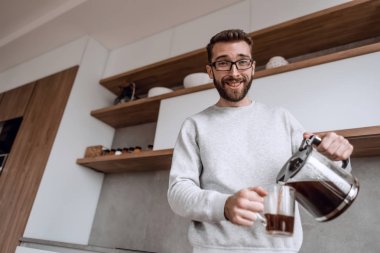 Kapat. Bir adam kendine sabah kahvesi dolduruyor.