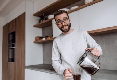 Kapat. Bir adam kendine sabah kahvesi dolduruyor.