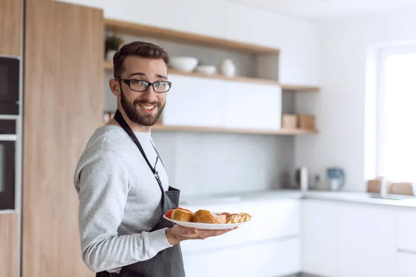 Тарелка сэндвичей в руках привлекательного мужчины — стоковое фото