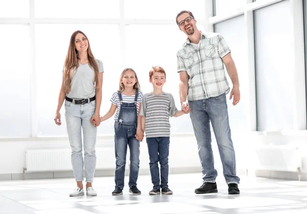 Счастливые родители с детьми, стоящими в новой квартире — стоковое фото