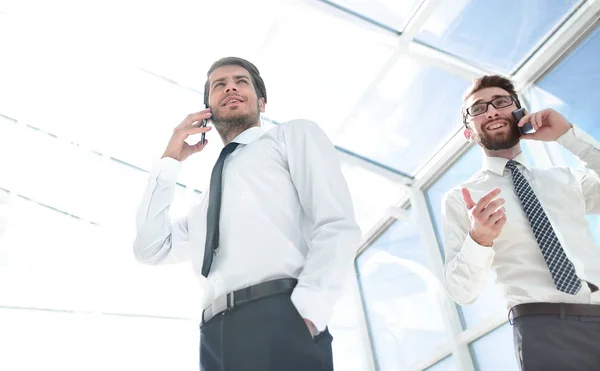 Bottom view.business people talking on their mobile phone in the office. — Stock Photo, Image