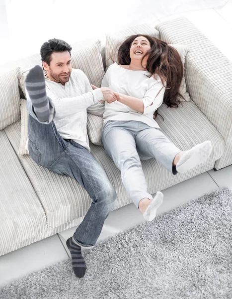 Laughing couple having fun on the couch in the living room — Stock Photo, Image