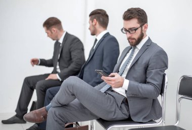 Grup ofis alma içinde oturan bir toplantı için bekleyen iş adamları.