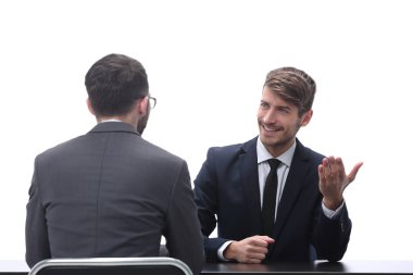 Masada oturan iki iş adamı konuşuyor.