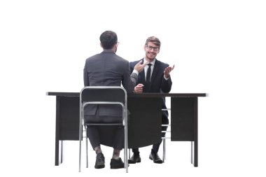 Masasında oturan iki iş adamı konuşuyor.