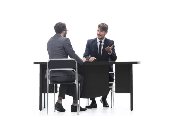 Два деловых человека разговаривают сидя за рабочим столом — стоковое фото