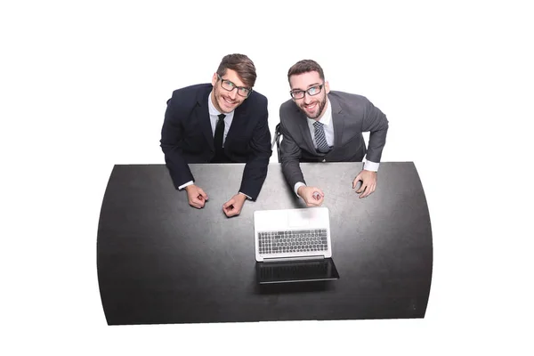 Top view. smiling business colleagues sitting in front of an open laptop Stock Image