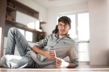 Genç adam akıllı telefonundan mesajlar okuyor.