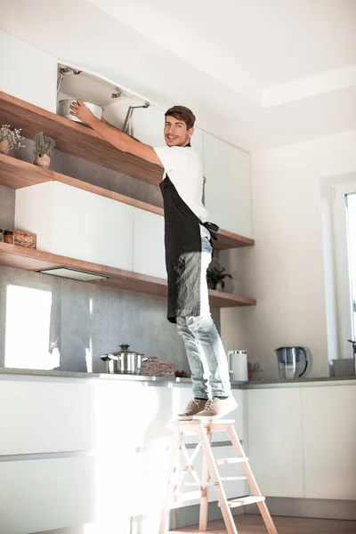 Człowiek stoi na rozstawna w domowej kuchni — Zdjęcie stockowe