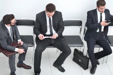 Ofis koridorunda bir iş belgesini tartışan çalışanlar