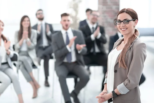 Affärskvinna på suddig bakgrund av lyssnare i konferensrum — Stockfoto