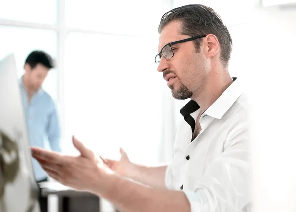 Affärsman som talar medan du sitter vid sitt skrivbord — Stockfoto