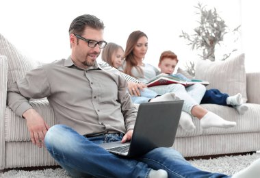 Onun evinde dizüstü bilgisayar kullanan genç adam