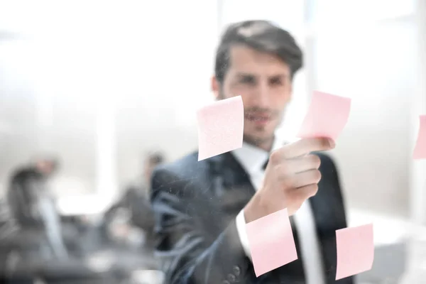 Joven empresario leyendo una nota sobre el vidrio . —  Fotos de Stock