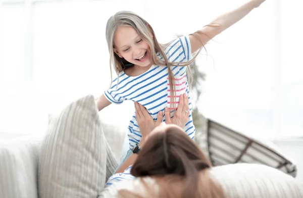 Mamá y su hija tumbadas en el sofá de la sala . —  Fotos de Stock