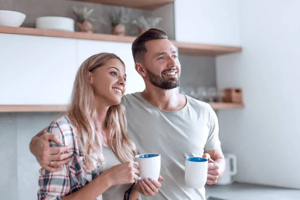 Joven pareja bebiendo café de pie en la cocina — Foto de Stock