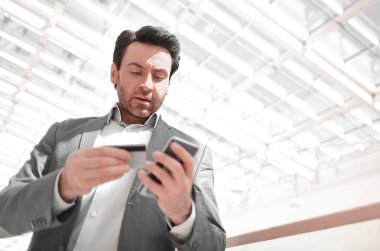 Kapat. İş adamı akıllı telefondan numarayı arıyor.