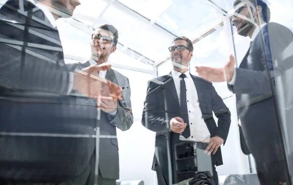 Grupp av affärsmän som står i ett rymligt kontor — Stockfoto