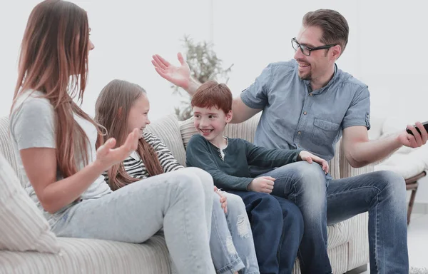 Веселая семья, сидящая на диване в гостиной — стоковое фото