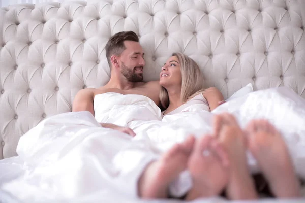 Kochająca się para rozmawiająca leżąc na łóżku — Zdjęcie stockowe