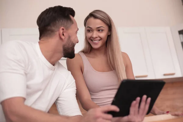 Casal jovem navegando na web com tablet em casa cozinha — Fotografia de Stock