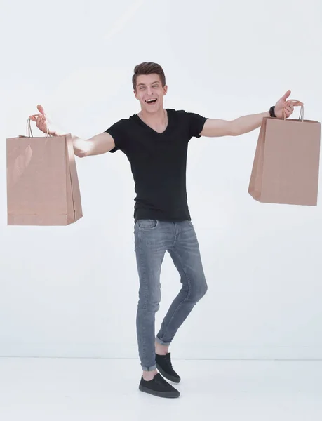 Glimlachend jongeman uitvoering van boodschappentassen — Stockfoto