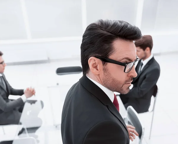 Sidovy. seriös affärsman som står i konferensrummet — Stockfoto