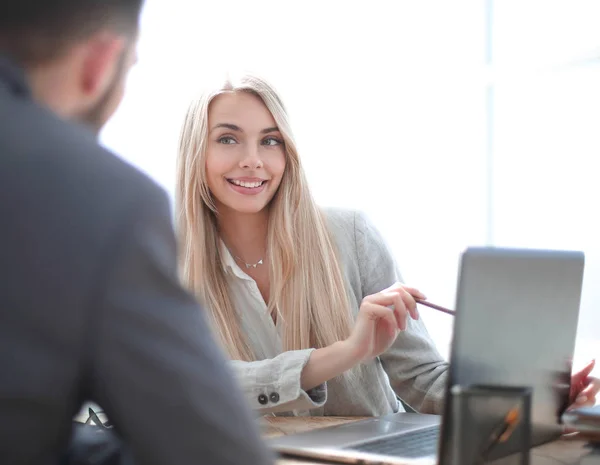 Uśmiechnięta businesswoman wyjaśniając coś swojemu koledze — Zdjęcie stockowe