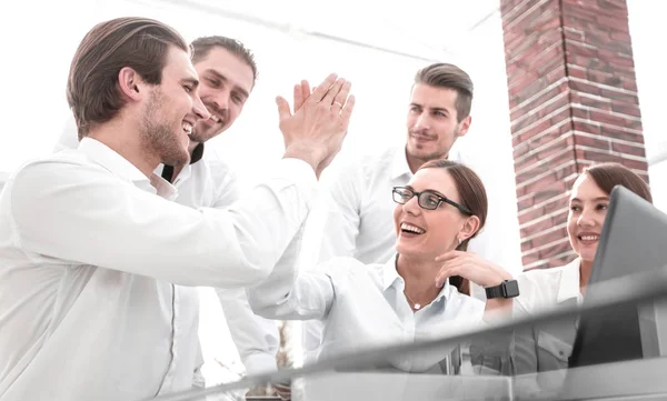 Employees give each other a high five sitting at the Desk — Stock Photo, Image