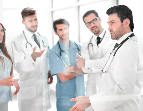 Группа медицинского персонала обсуждается в коридоре клиники — стоковое фото