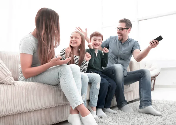 Счастливая семья, сидящая у телевизора в своем доме — стоковое фото