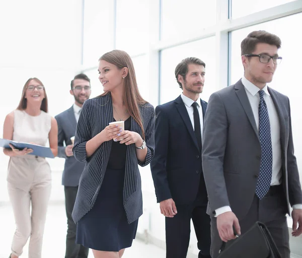 Gente de negocios que va a lo largo del pasillo de la oficina durante la jornada laboral — Foto de Stock