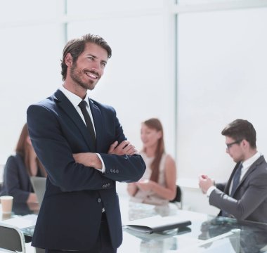 ofisinde duran gülümseyen genç işadamı