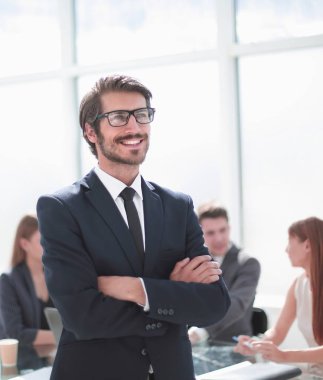 ofisinde duran gülümseyen genç işadamı