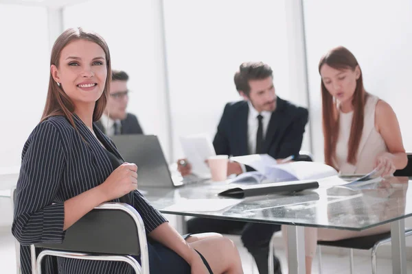 Junge Geschäftsfrau sitzt am Bürotisch — Stockfoto