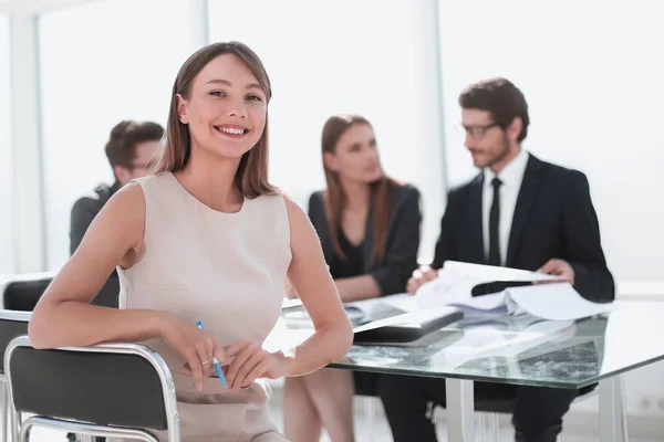 Femme d'affaires souriante assise à la table du bureau — Photo