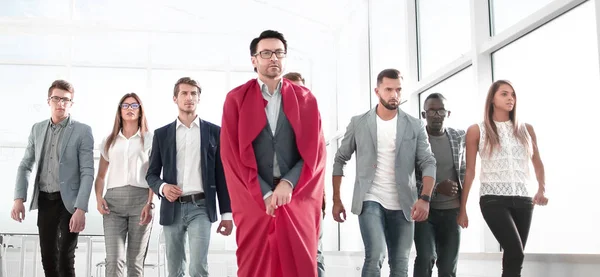 Businessman in a superhero cloak leads a business team — Stock Photo, Image