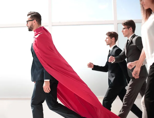 Hombre de negocios superhéroe y su equipo de negocios caminando en la oficina — Foto de Stock