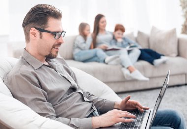 oturma odasında bir dizüstü bilgisayar kullanan başarılı adam