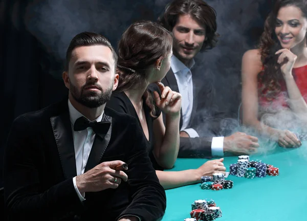Man with cigar looking up from poker game in casino — Stock Photo, Image