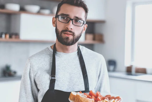 Plate of sandwiches in the hands of an attractive man — Stock Photo, Image