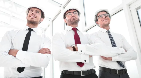 Three architects standing in an empty office — Stock Photo, Image