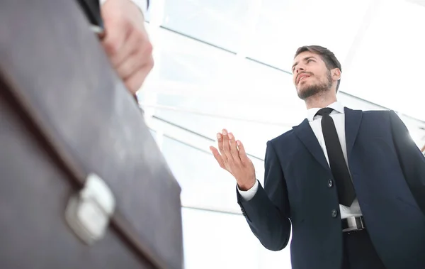 Unbekannter Geschäftsmann mit Koffer in Großaufnahme vor modernem Hintergrund — Stockfoto