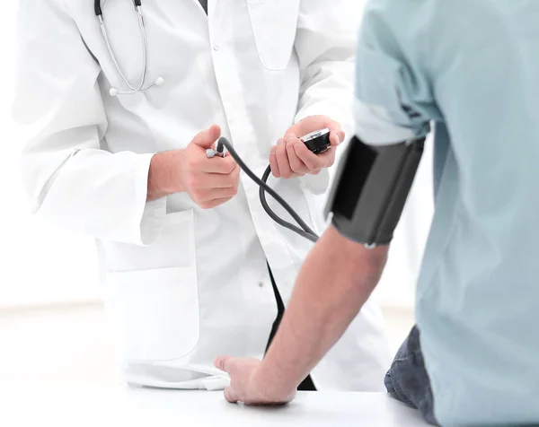 Médico midiendo la presión arterial con esfigmomanómetro — Foto de Stock