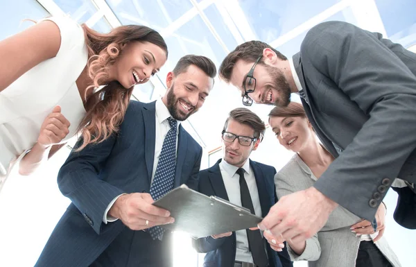 Equipo de negocios mirando el portapapeles con el informe financiero —  Fotos de Stock