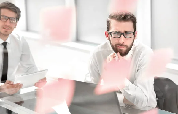 Two thoughtful employees sitting at a Desk. — Stock Photo, Image